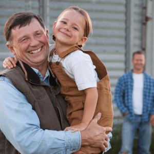 Happy farmer holding daughter in his arms