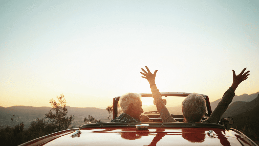 A senior couple enjoying the sunset on an afternoon drive